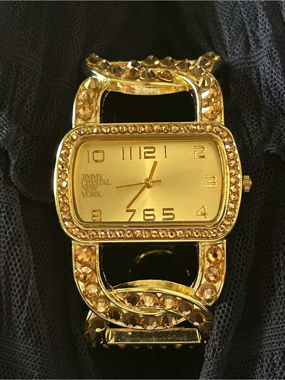 Jimmy Crystal elegant gold tone cuff watch with sparkling crystal accents.